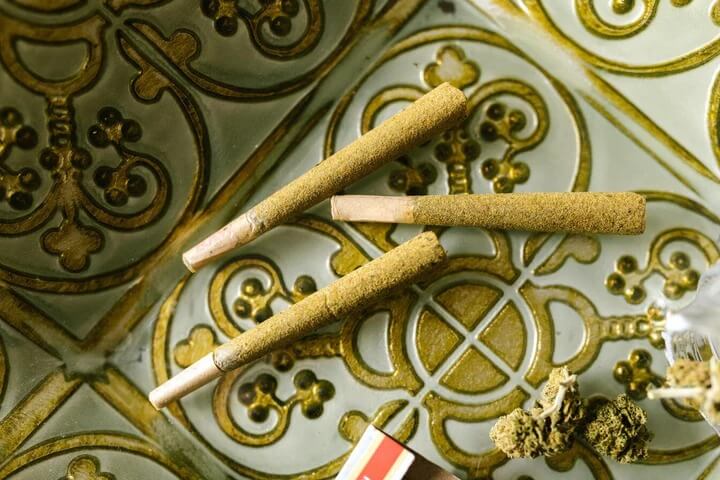 Pre-rolled joints with kief and flower on decorative tile